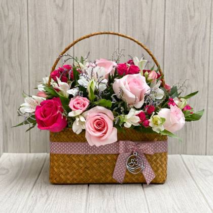 CANASTO CON FLORES TONOS ROSADOS